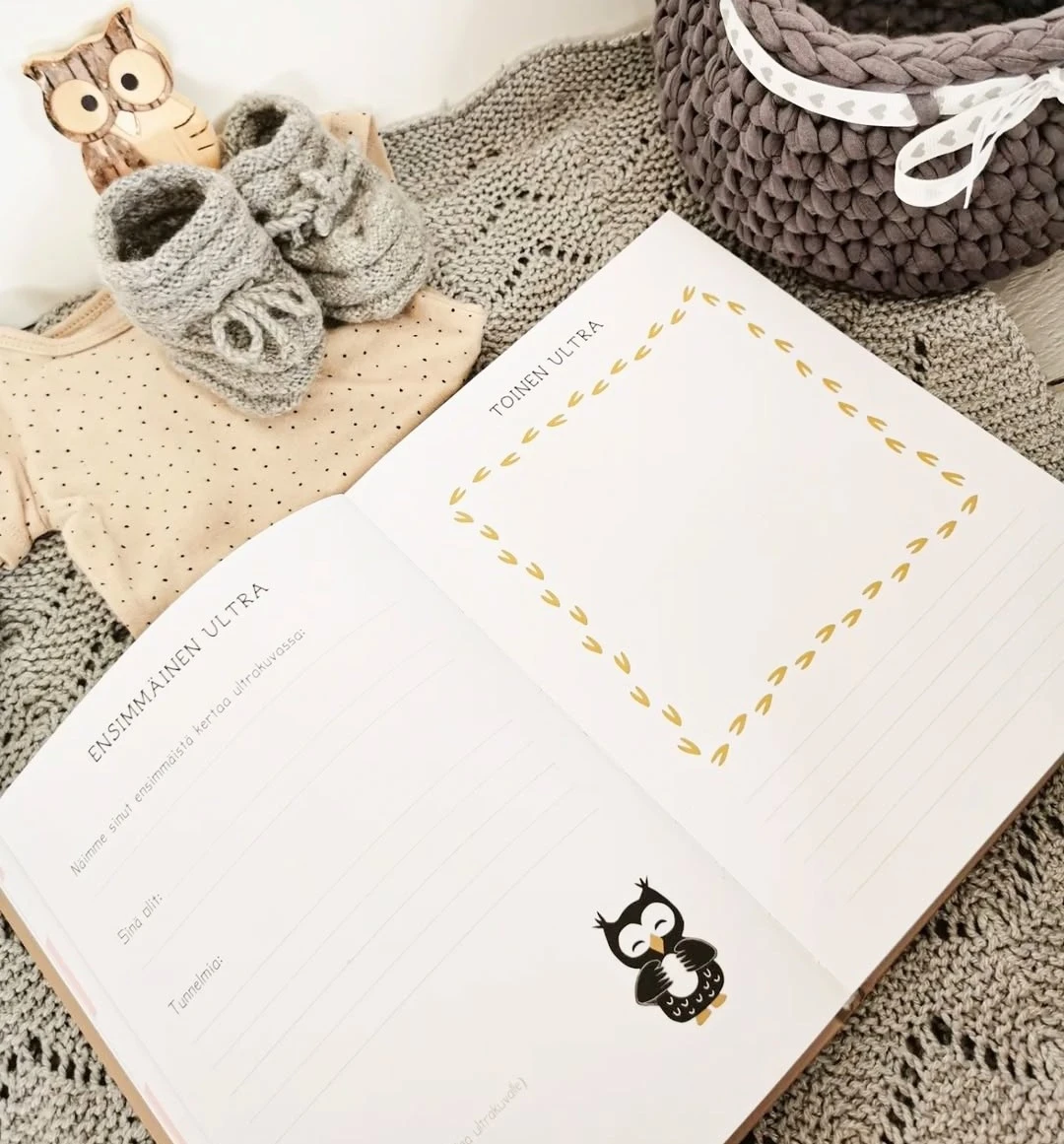 Käsi asettamassa ultrakuvaa Pieni Rakas -vauvakirjan sivulle